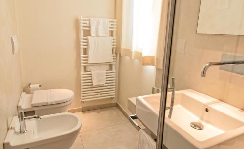 a white bathroom with a toilet and a sink at Hotel Country House La Radice in Civitanova Marche