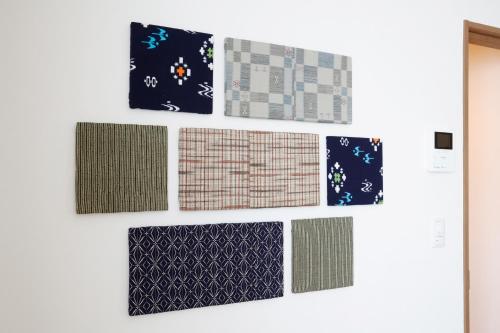 a wall of different types of patterns on a white wall at AOI in Furano