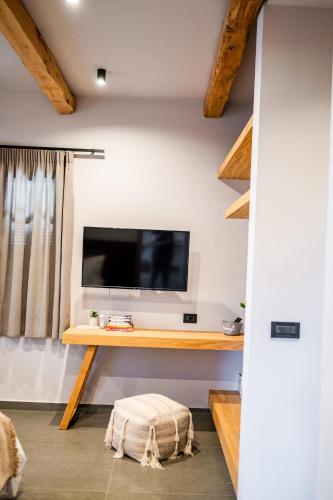 a living room with a desk with a television on a wall at ANDROMEDA in Kalymnos