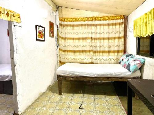 um pequeno quarto com um banco num quarto em Tina Transient Home em Cayluya