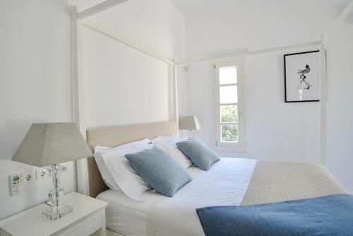 - une chambre blanche avec un lit et une fenêtre dans l'établissement Elysian villa, à Spetses