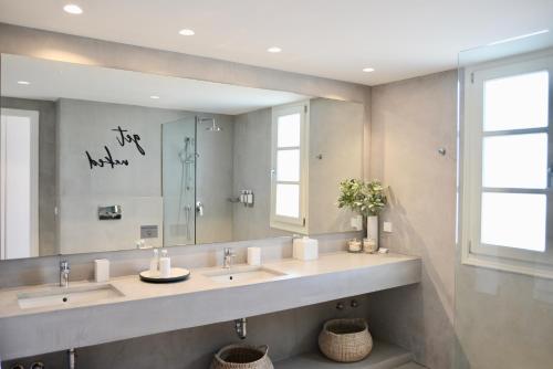 La salle de bains est pourvue de 2 lavabos et d'un grand miroir. dans l'établissement Elysian villa, à Spetses