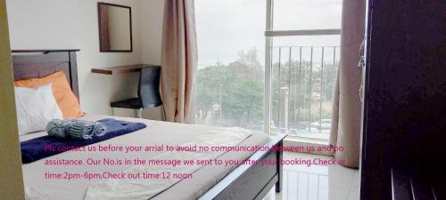 a bedroom with a bed and a window with a sign on it at SMDC Tagaytay Taal Lake Condo Cook Netflix No Balcony No Free Parking Contact to Confirm in Tagaytay