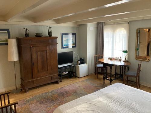 a bedroom with a bed and a table and a television at Vondelparkmuseum Inn in Amsterdam