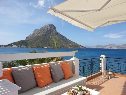 un sofá blanco en un balcón con vistas al océano en Aegean Villa-On beach apartment! Ideal choice! en Masouri