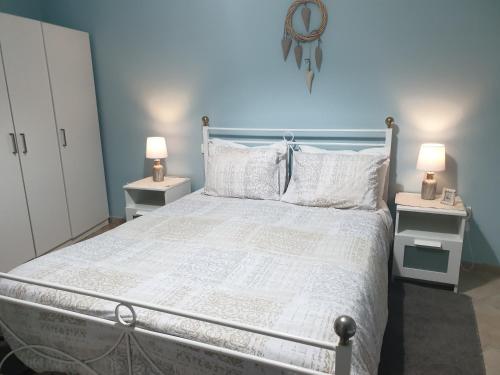 a bedroom with a white bed with two night stands at Aegean Villa-On beach apartment! Ideal choice! in Masouri