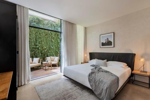 a bedroom with a bed and a large window at The Vera in Tel Aviv