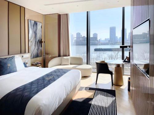 上海市にあるProdor Hotel Shanghaiのベッドと大きな窓が備わるホテルルームです。