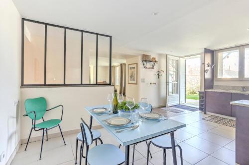une salle à manger avec une table et des chaises bleues dans l'établissement La Sablière - Appt à 50m de la plage, à Pléneuf-Val-André