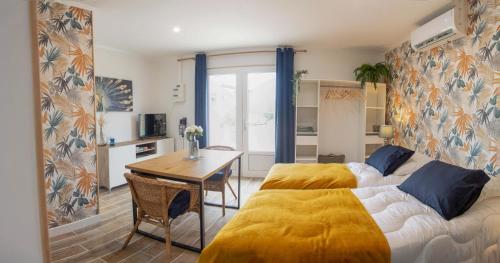 een slaapkamer met een bed, een tafel en een bureau bij Le colibri in Cazaubon
