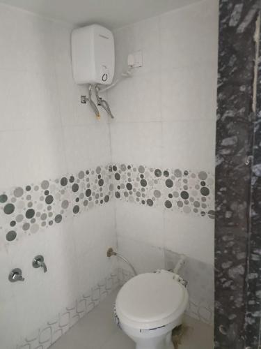 een badkamer met een wit toilet en een douche bij ashapura home stay in Navgam