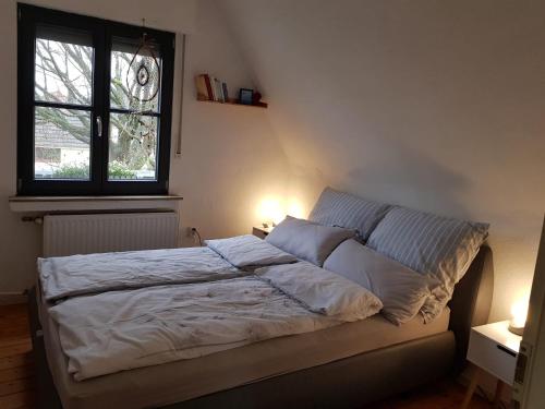 Ferienwohnung Niederrhein في فيسيل: سرير في غرفة نوم مع مصباحين
