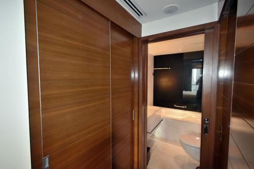 bagno con porta in legno e servizi igienici. di The Address Dubai Mall Residences - Deluxe Studio a Dubai