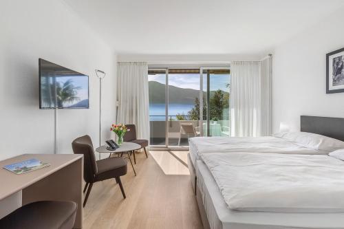 a hotel room with a bed and a table and chairs at Casa Berno Panorama Resort in Ascona