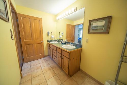 W łazience znajduje się umywalka i lustro. w obiekcie Black Bear 8035 w mieście Keystone