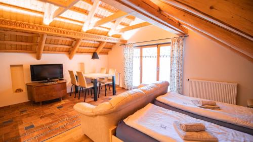 a living room with a couch and a tv and a table at Vila Triglav on Pokljuka in Goreljek
