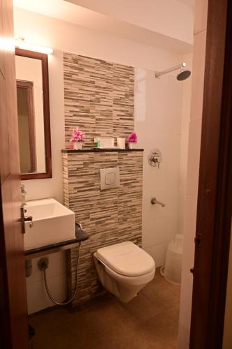 a bathroom with a toilet and a sink at Grand Cascade Chennai in Chennai