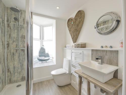 a bathroom with a sink and a toilet and a mirror at Ocean View in Marazion