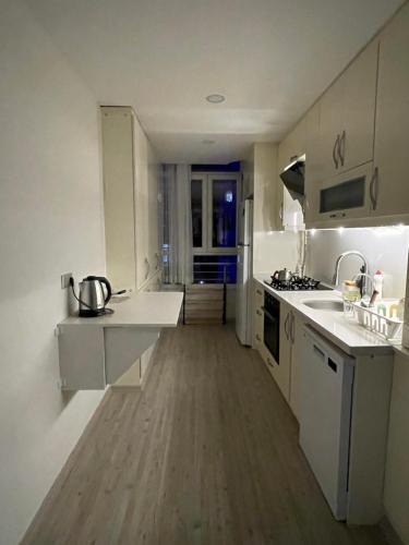 cocina con electrodomésticos blancos y suelo de madera en Flance hotel furnished home with all amenites, en Basaksehir