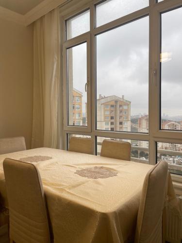 a table and chairs in a room with a large window at Flance hotel furnished home with all amenites in Basaksehir