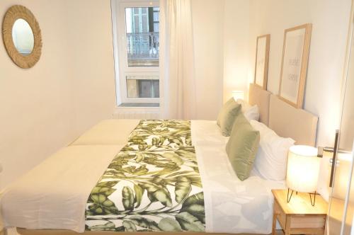 a white bedroom with a large bed with a window at Mirador Catedral de Santiago in Bilbao