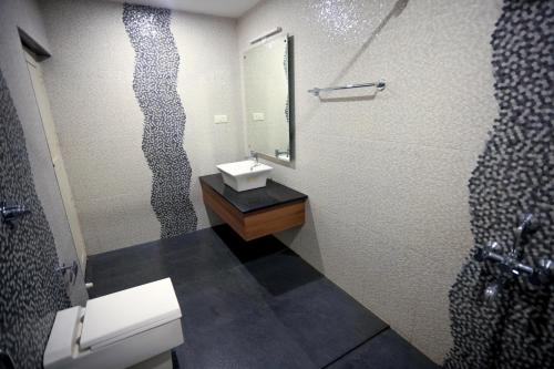 a bathroom with a toilet and a sink and a mirror at Mistygreen Homestay Thekkady in Thekkady