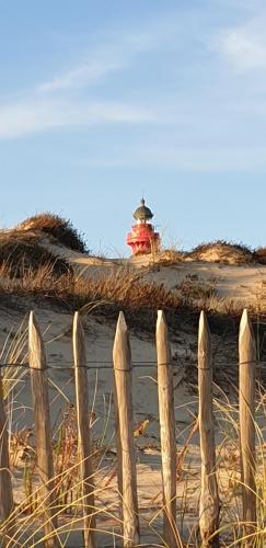 a fence on the beach with a fire hydrant in the background at Mobil'home proche du zoo de La Palmyre promotion séjour 2 jours in Les Mathes