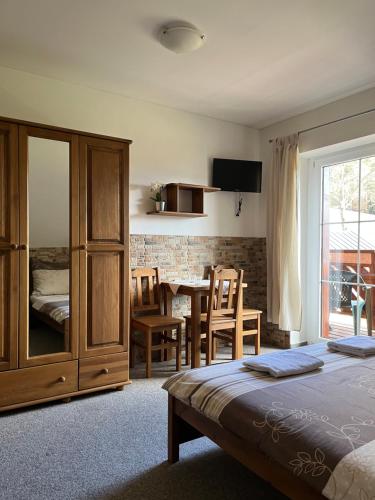 a bedroom with a bed and a dining room at Na Planýrce in Paseky nad Jizerou