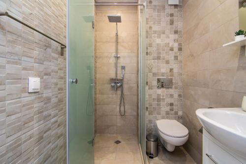 a bathroom with a shower with a toilet and a sink at Cozy flats nearby center free park area in Varna City