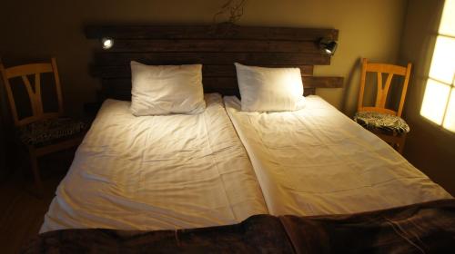 Una cama con sábanas blancas y almohadas en un dormitorio en Kloten Nature Resort, en Kopparberg