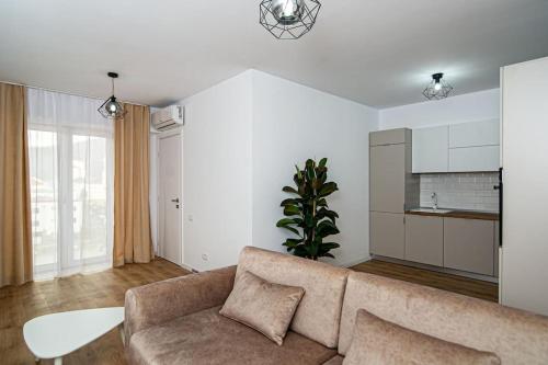 een woonkamer met een bank en een tafel bij City Center Accommodation - 404 in Reşiţa