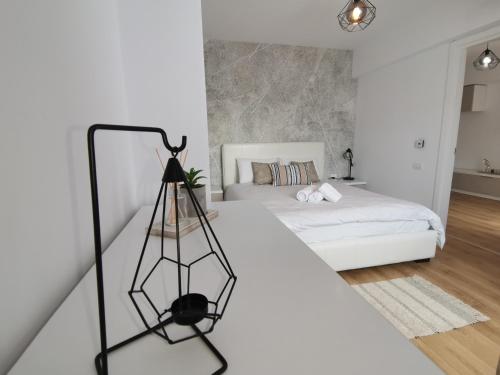 een witte slaapkamer met een wit bed en een zwart-wit bed bij City Center Accommodation - 404 in Reşiţa