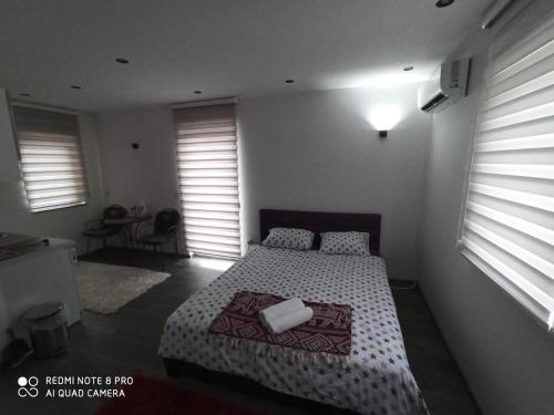 a bedroom with a bed in a room with windows at Apartmani Kula in Tuzla