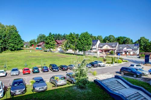 un estacionamiento lleno de autos estacionados en un estacionamiento en Solina Resort, en Polańczyk