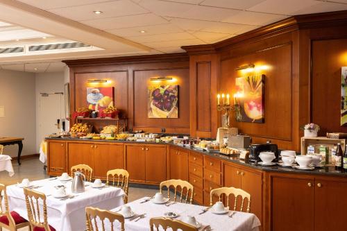 a dining room with tables and chairs in a restaurant at Hotel Bristol in Mulhouse