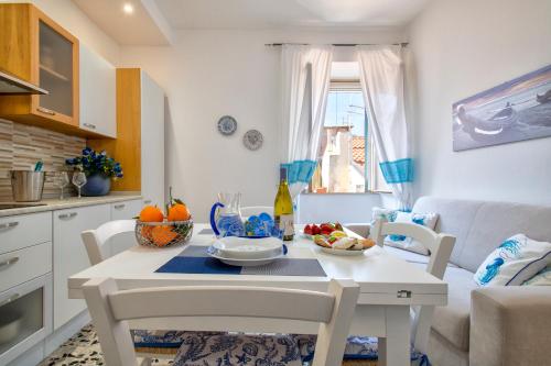 a kitchen and living room with a white table and chairs at Casa Vacanze San Michele in Alghero
