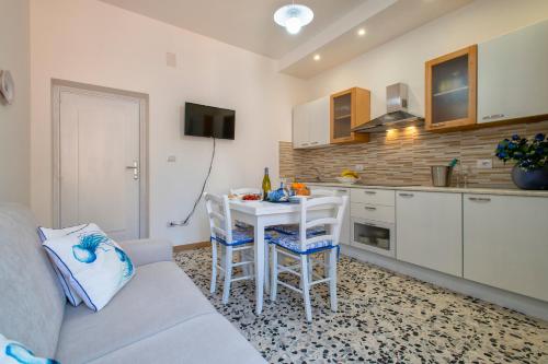 a living room with a couch and a table in a kitchen at Casa Vacanze San Michele in Alghero