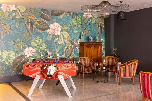 a room with a table and a floral wall at Hotel Bristol in Mulhouse