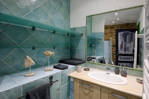 een badkamer met een wastafel en een spiegel bij La Belle Rivière in Bolozon
