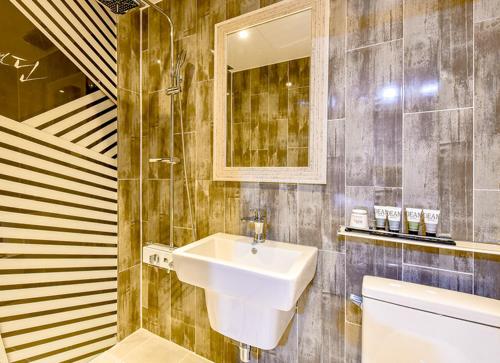 La salle de bains est pourvue d'un lavabo et d'un miroir. dans l'établissement Changwon Dean Hotel, à Changwon