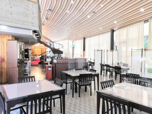 函南町にある南箱根ヴィラのテーブルと椅子のあるレストラン、キッチンが備わります。