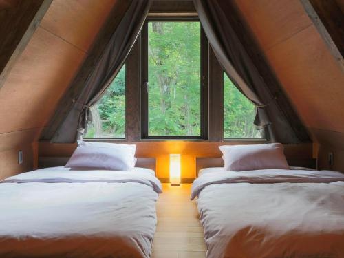 two beds in a room with two windows at Villa Yoshino - Vacation STAY 01536v in Azumino