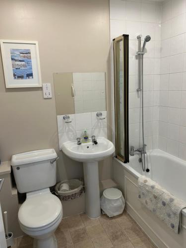 een badkamer met toilet, wastafel en bad bij Fernhill Retreat in Charmouth