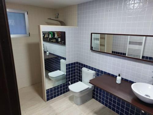 uma casa de banho em azulejos azuis com um WC e um lavatório em Tossal Home em Castillo del Reboller