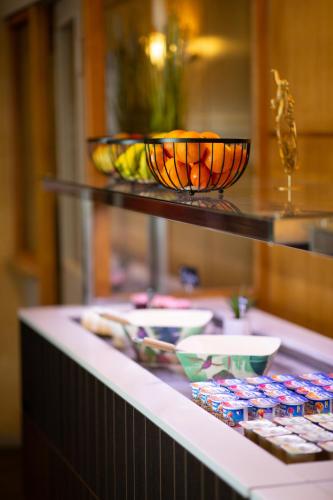 uma linha de buffet com pratos e tigelas em cima em Hôtel Confort Le Moulin Rouge em Terrasson