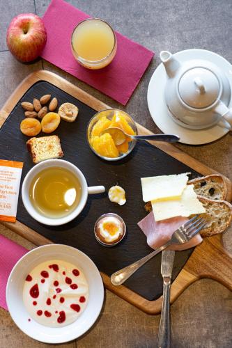 uma bandeja de comida com queijo e uma xícara de café em Hôtel Confort Le Moulin Rouge em Terrasson