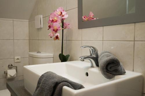 a bathroom sink with two towels and a flower at Ferienwohnungen Jodlbauerhof in Weyregg