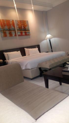 a hotel room with two beds and a table at Hotel Sindha in Ruteng