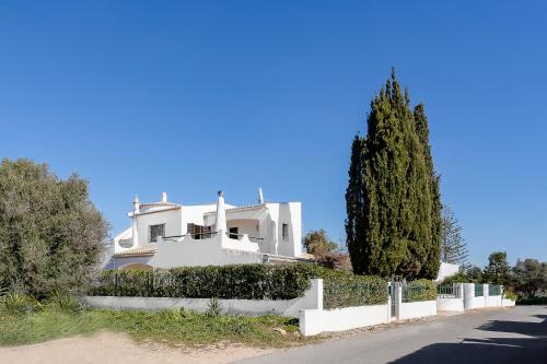 a white house with a fence and a tree at Casa Branca in Estômbar