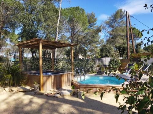 une piscine avec un kiosque en bois et une piscine dans l'établissement MAISON 5 Personnes EN GARRIGUE - PISCINE-SPA PRIVÉ, à Langlade